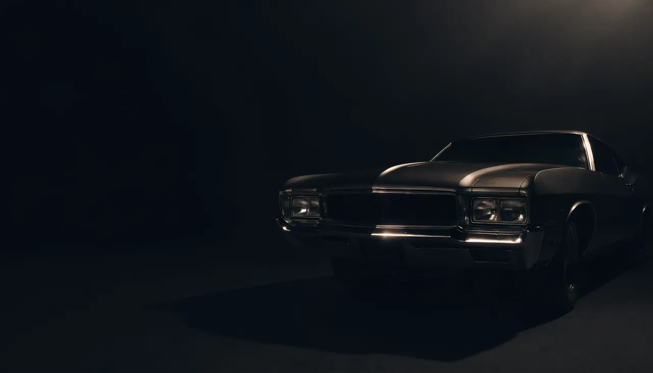 Classic American muscle car emerging from deep shadow